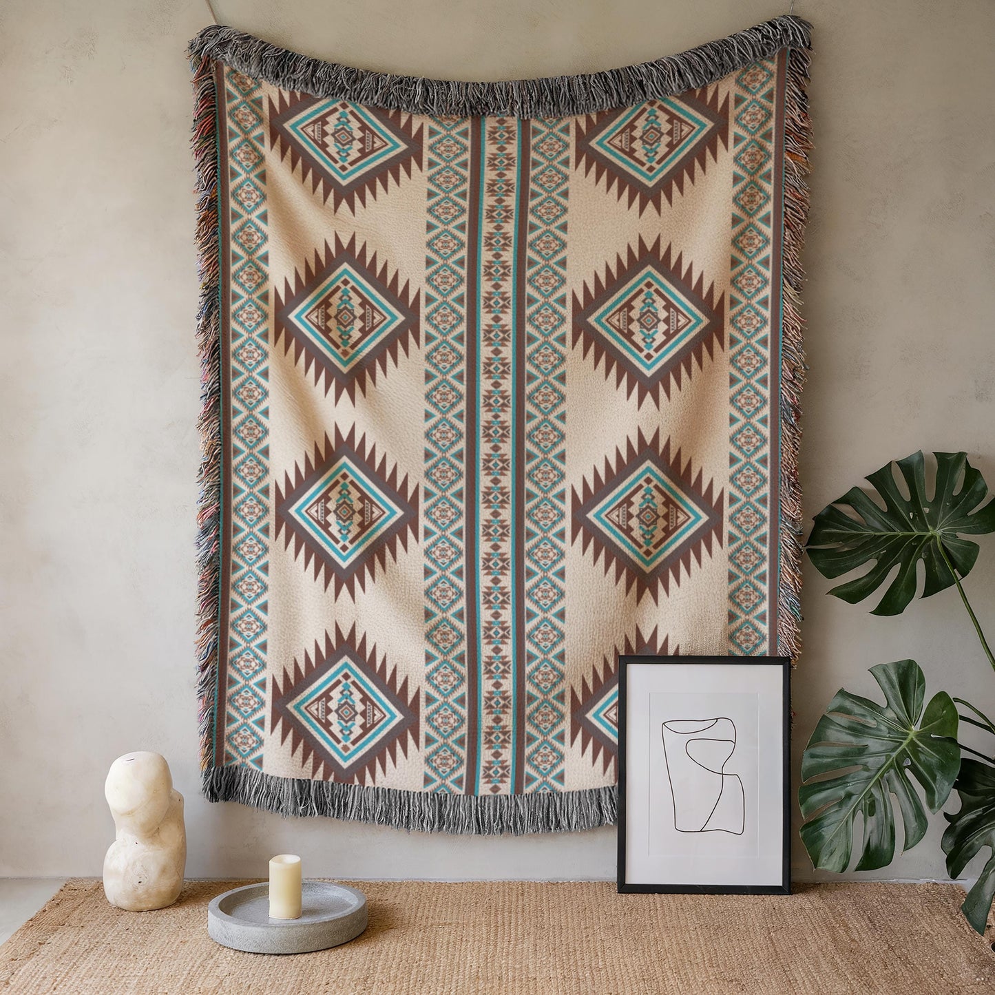 a wall with a decorative woven blanket hanging on it, accompanied by a framed artwork and a small sculpture. The blanket has a geometric pattern in shades of brown and blue, and the artwork is a simple black and white line drawing. The sculpture is a small white vase.