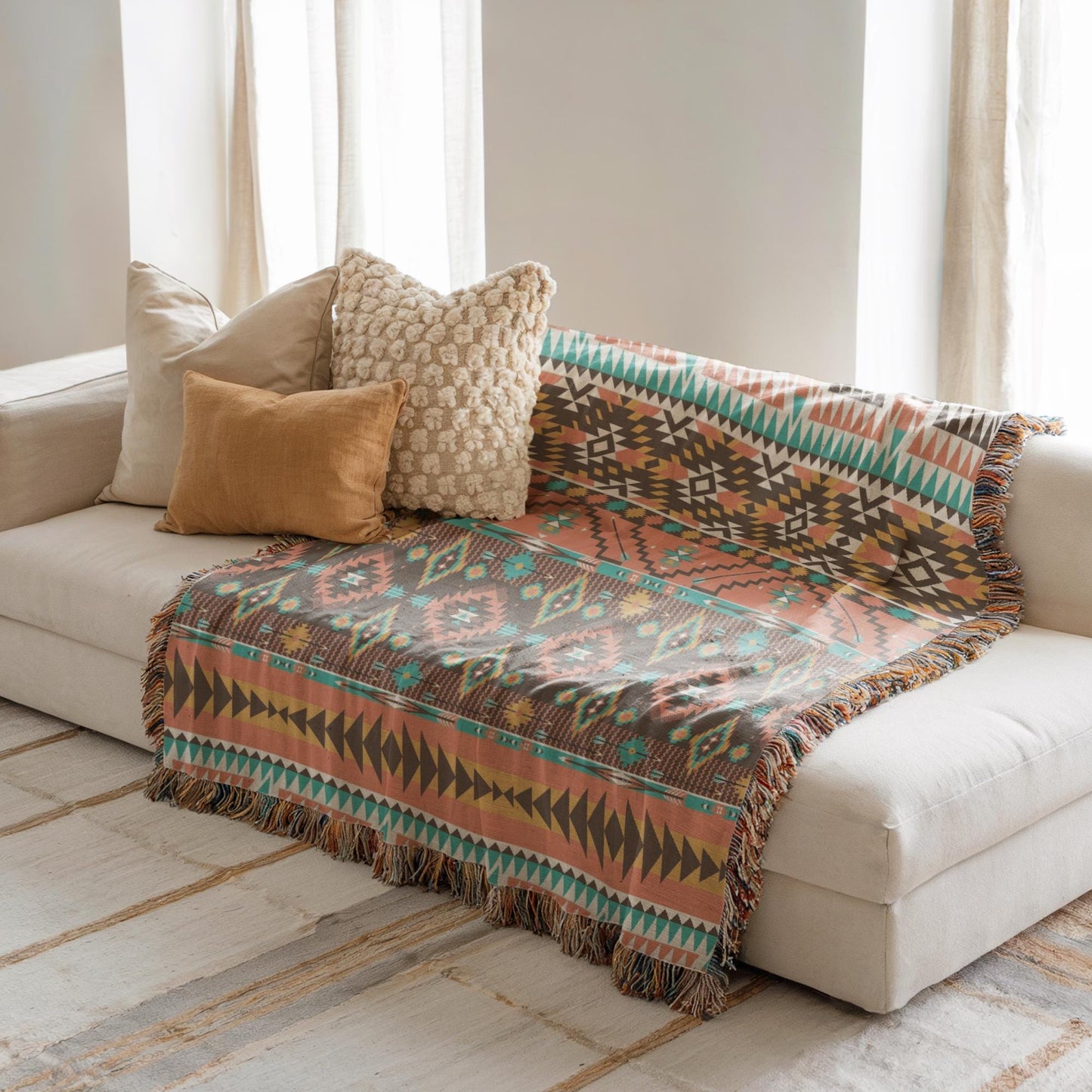 a cozy living room with a white sofa adorned with a colorful patterned blanket and three decorative pillows.