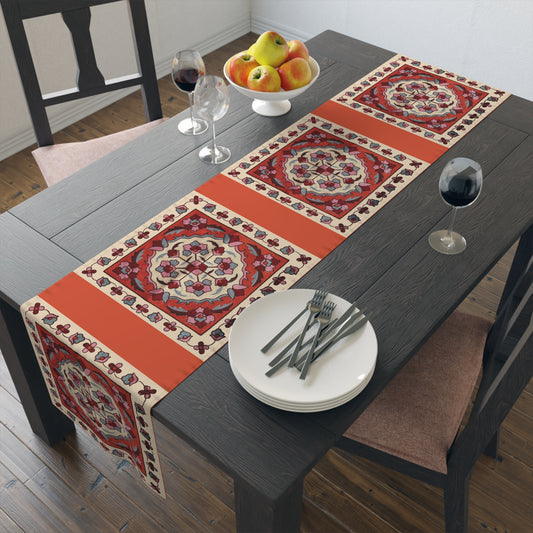 Western Armenian carpet table runner in red and cream on a dining table with wooden chairs and a bowl of fruit