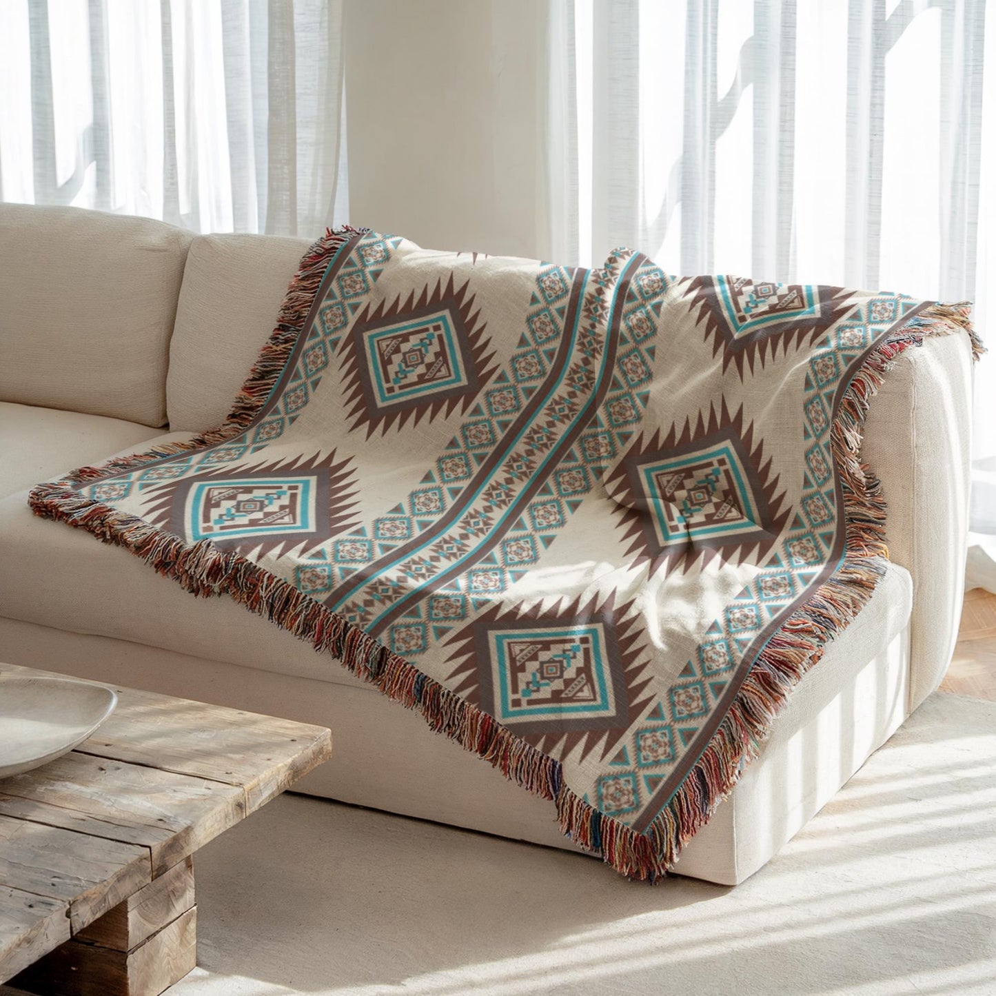 a cozy living room with a white couch and a wooden coffee table. A colorful, patterned blanket with fringe is draped over the back of the couch, adding a touch of warmth and texture to the space.