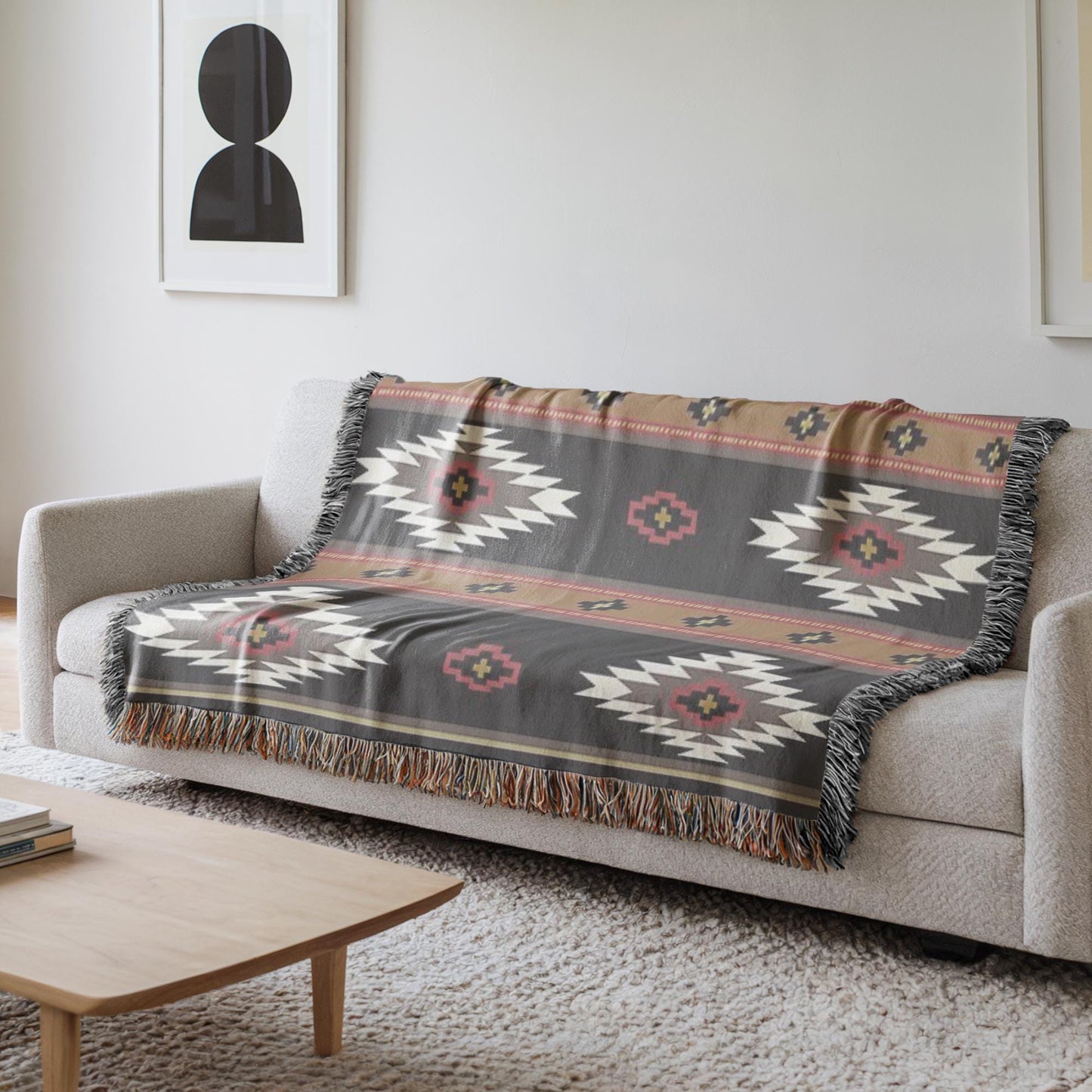 a gray couch with a decorative throw blanket on it, placed on a white rug in a living room setting.