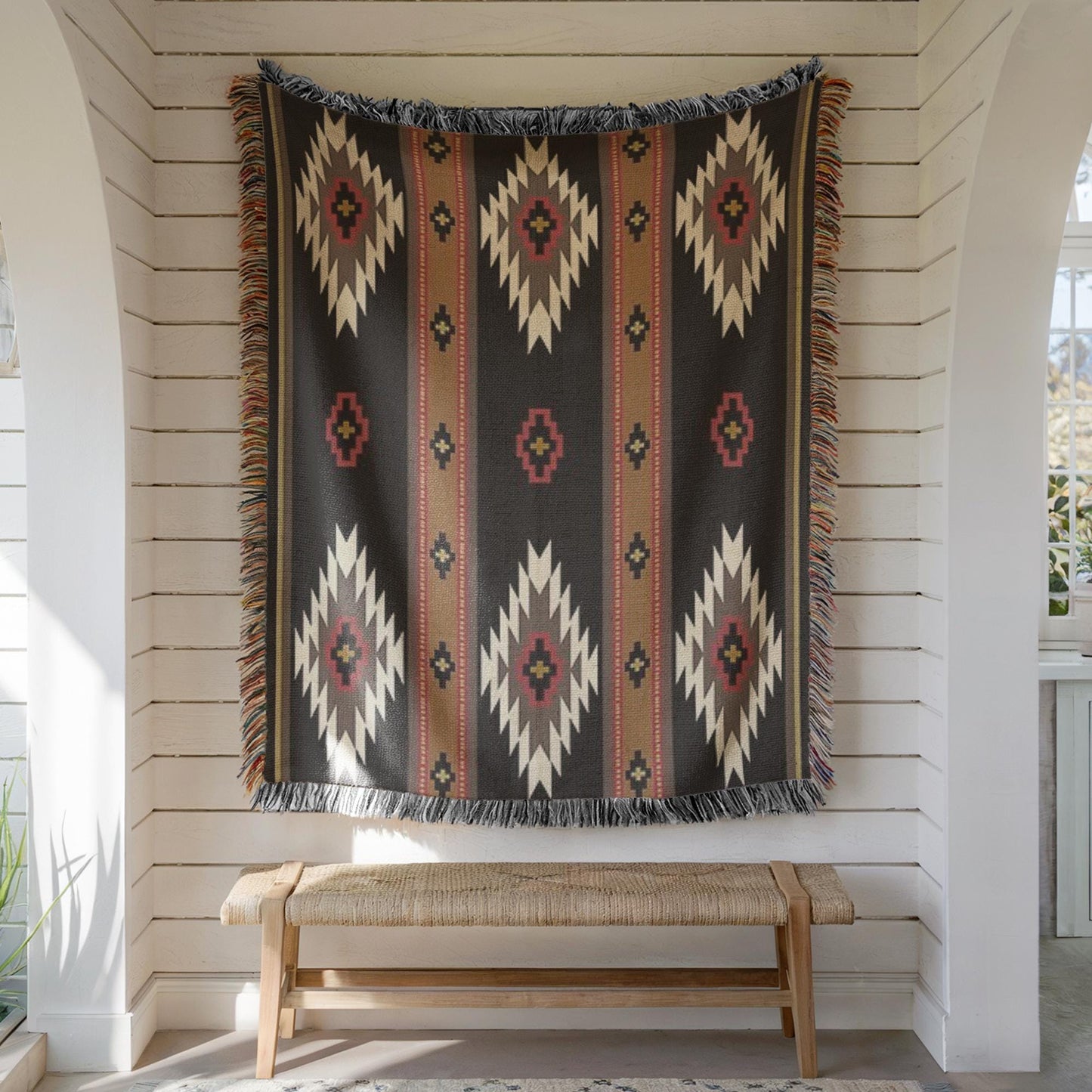 a large, colorful, patterned rug hanging on a white wall, with a wooden bench placed in front of it.