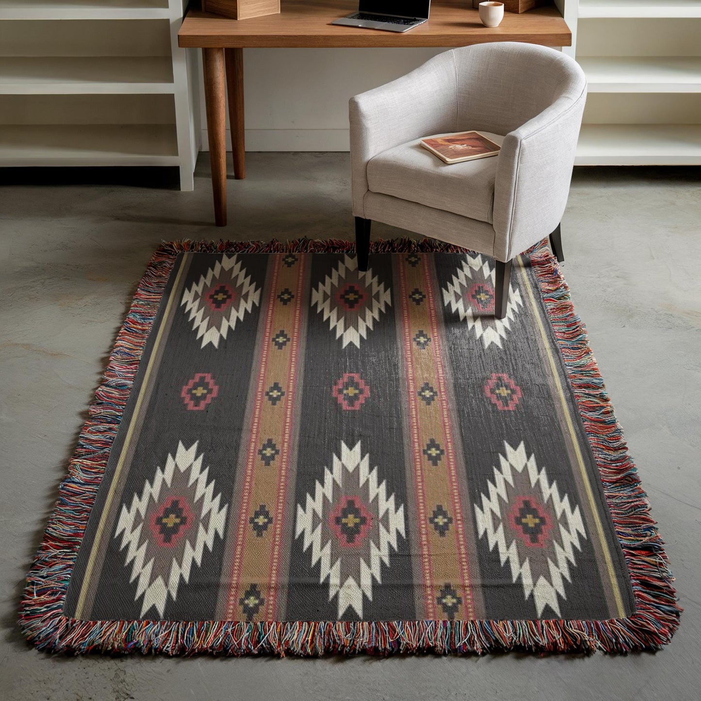 a cozy living room setting with a patterned area rug, a white armchair, and a wooden desk with a laptop on it.