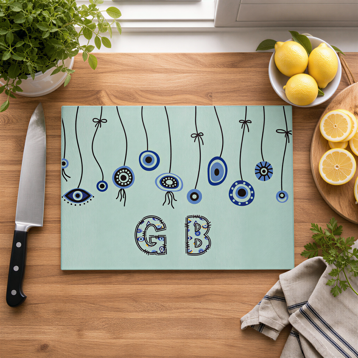 Evil eye cutting board on a wood counter with lemons, a knife and a folded cloth