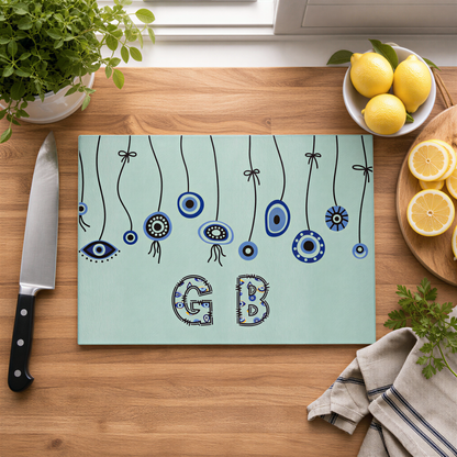 Evil eye cutting board on a wood counter with lemons, a knife and a folded cloth