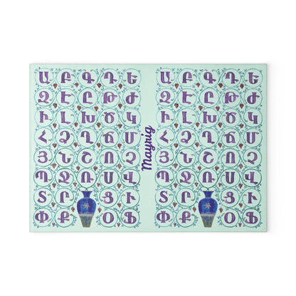 Mint Armenian alphabet cutting board with blue vases on a wooden worktop with a knife alongside
