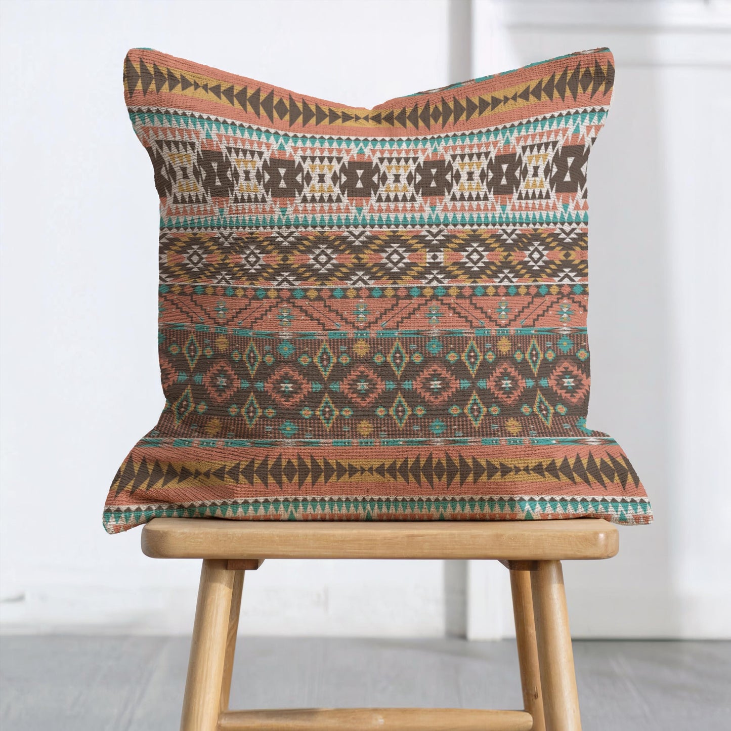 Southwestern throw pillow with geometric pattern styled on a sofa or bed
