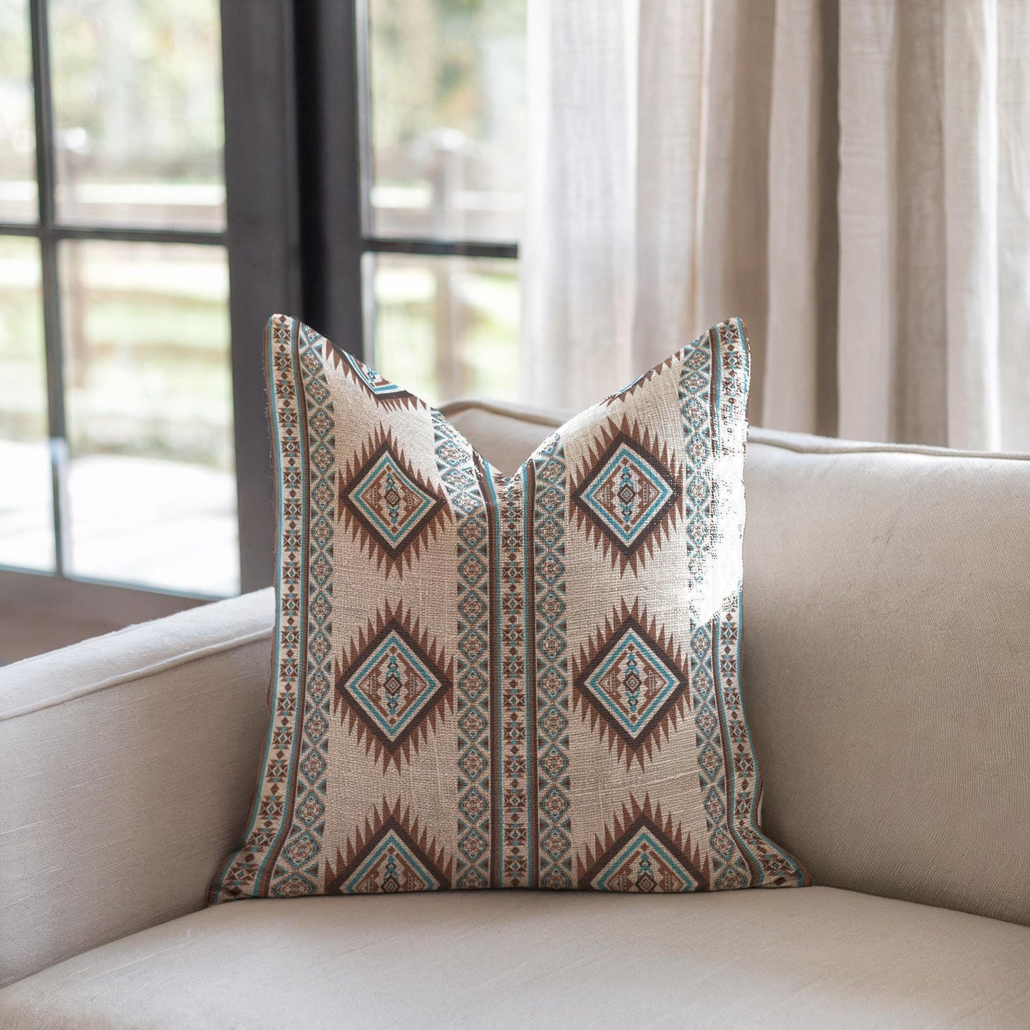 Southwestern throw pillow with geometric pattern styled on a sofa or bed