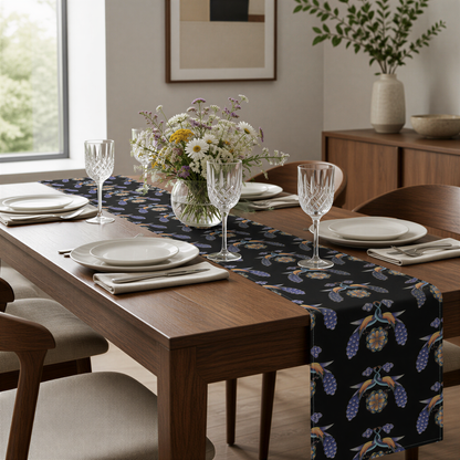Black Armenian bird and flower table runner on a dining table with wooden chairs and a bowl of fruit