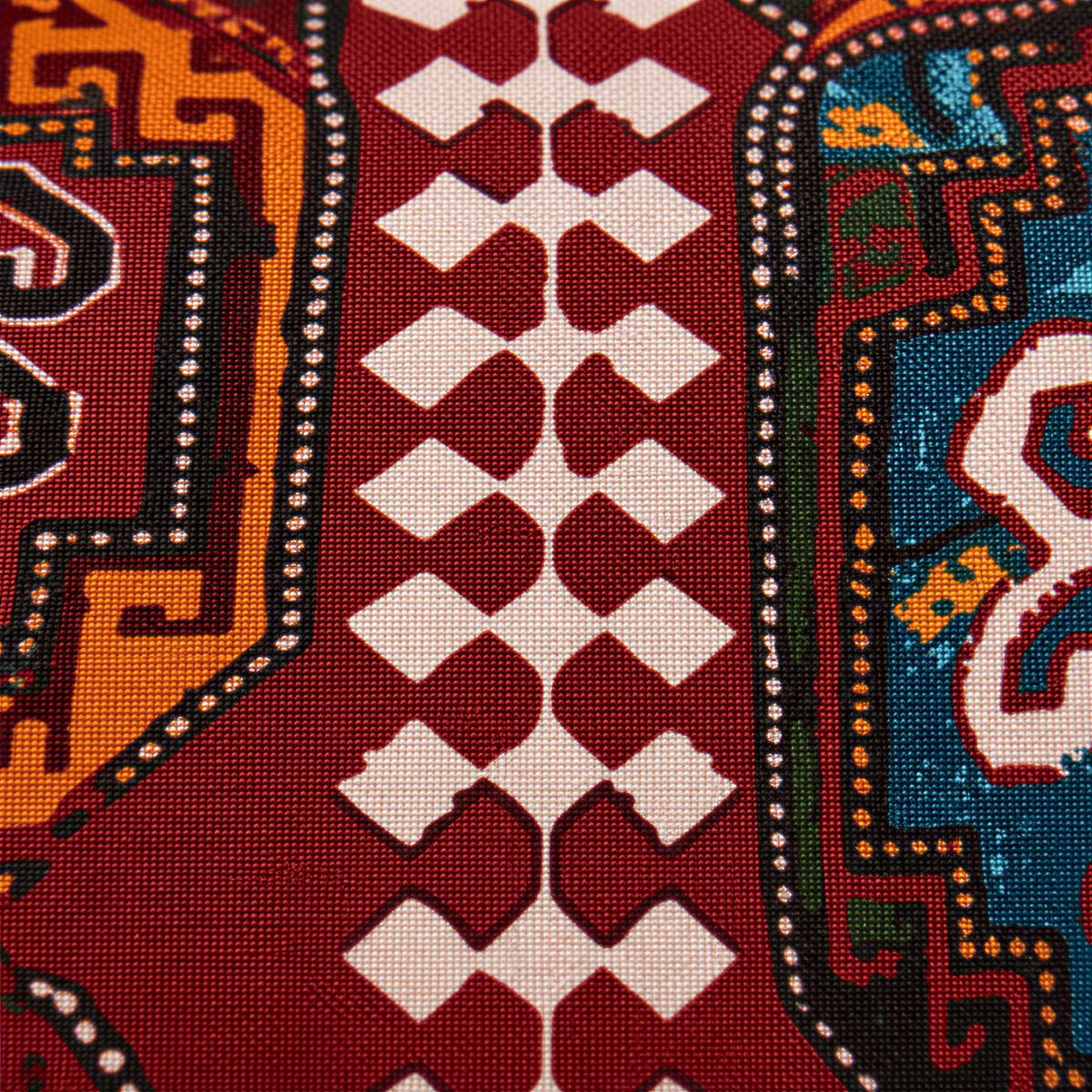 Close view of the burgundy carpet design with cream diamonds and orange and blue medallions