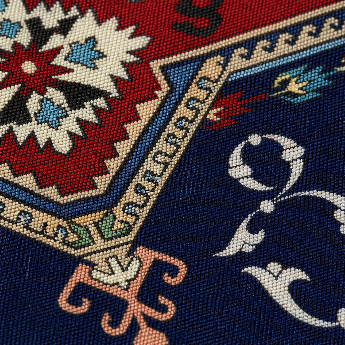 Close view of the red and cream star medallion with cream Armenian letters on navy
