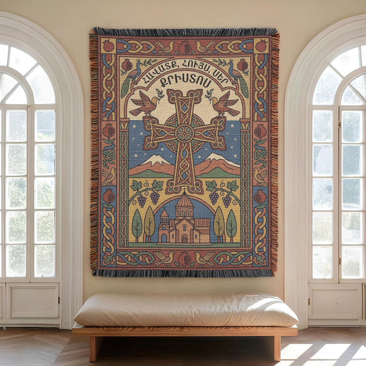 Woven Armenian cross wall hanging centred between two arched windows, cushioned bench below