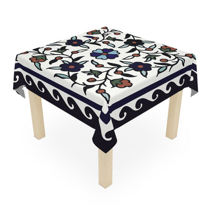 Navy bordered Armenian tablecloth on a rectangular table with wooden chairs and house plants