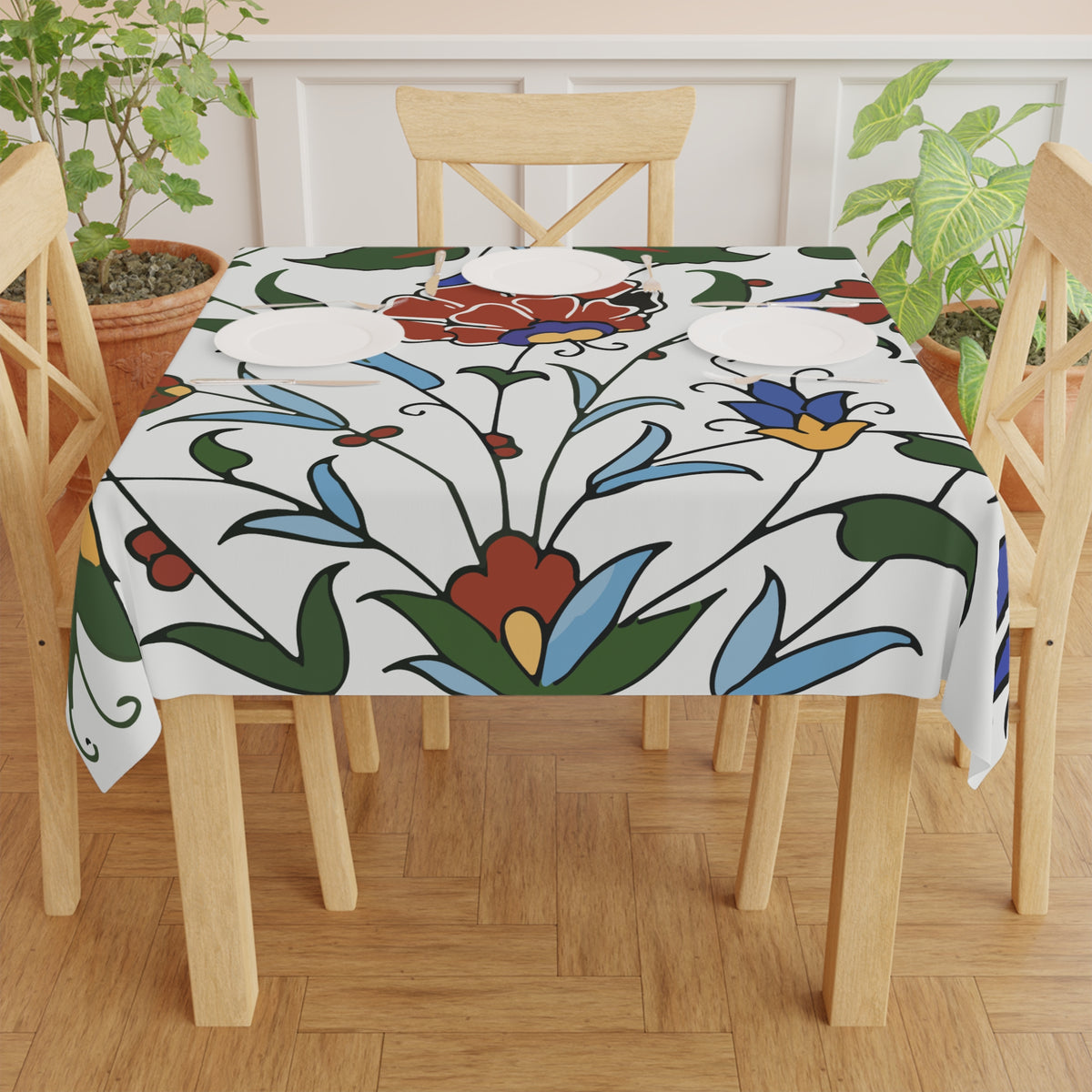 Blue and red Armenian pottery tablecloth on a round dining table with a vase and a bowl of fruit