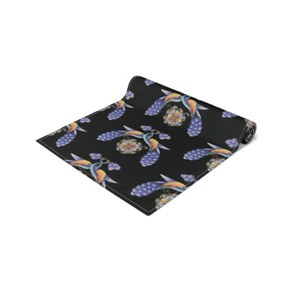 Black Armenian bird and flower table runner being laid on a dining table