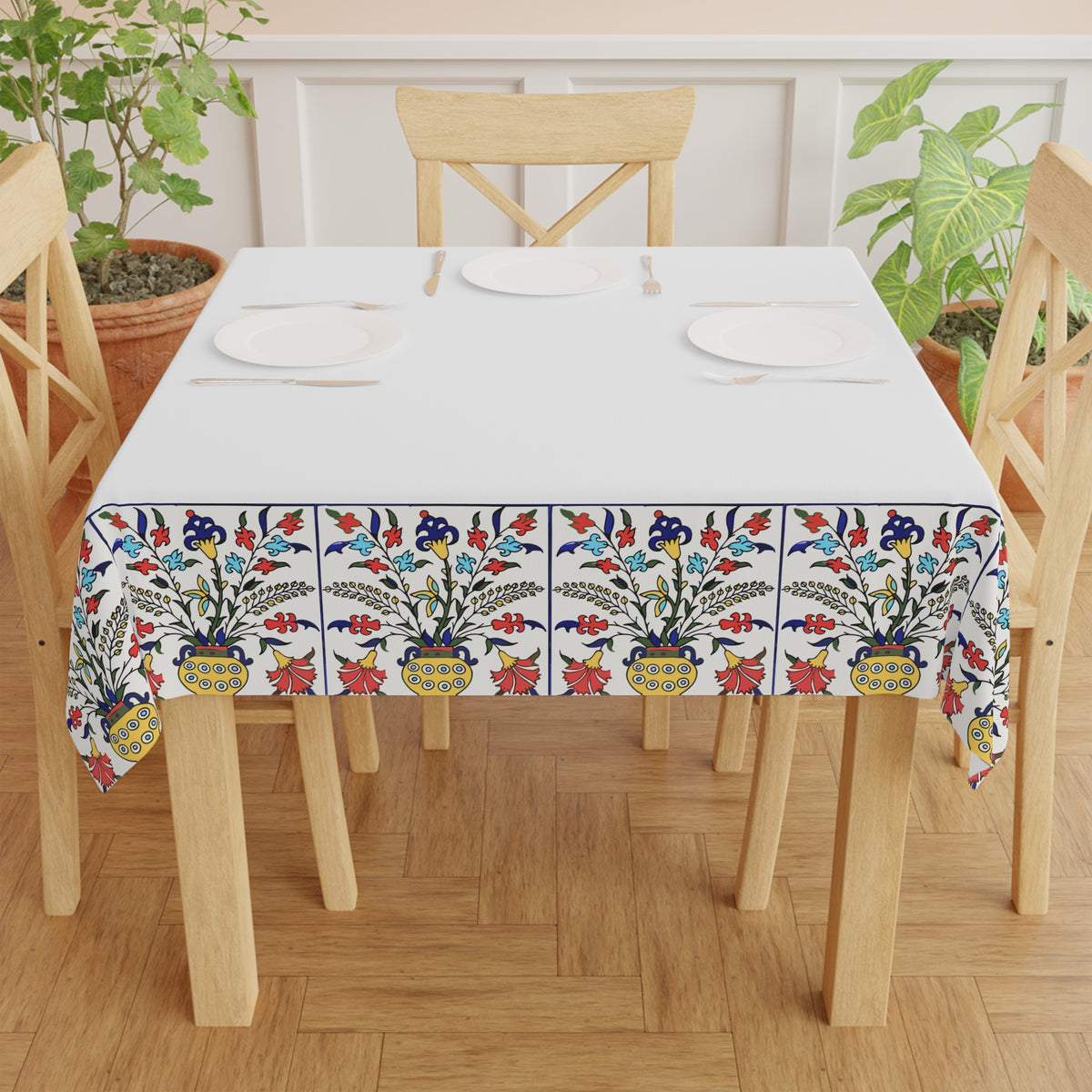 White Armenian tablecloth with floral border draped over a round table beside a window