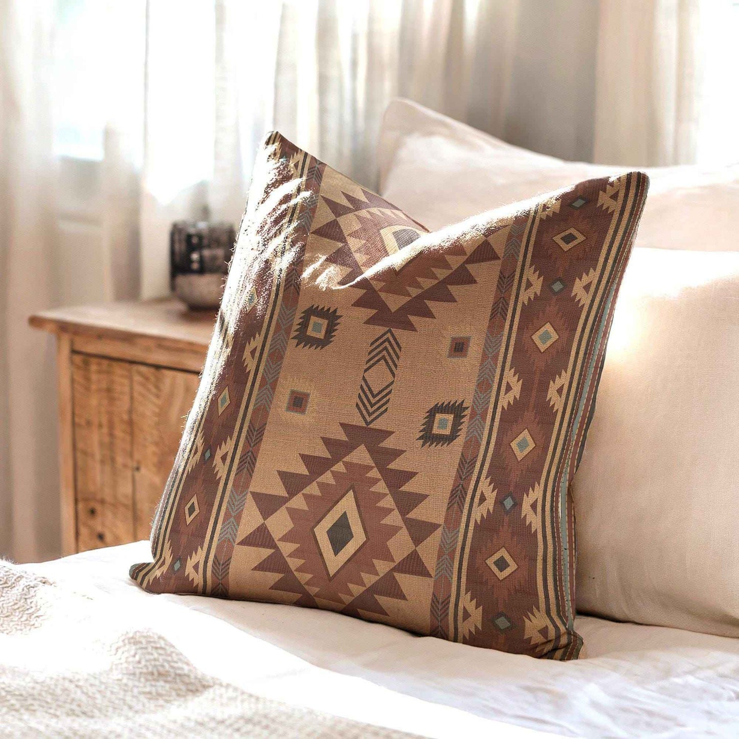 Southwestern throw pillow with geometric pattern styled on a sofa or bed