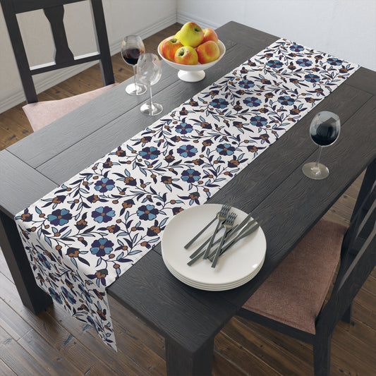 Cream Armenian Iznik poppy table runner on a dining table with wooden chairs and a bowl of fruit