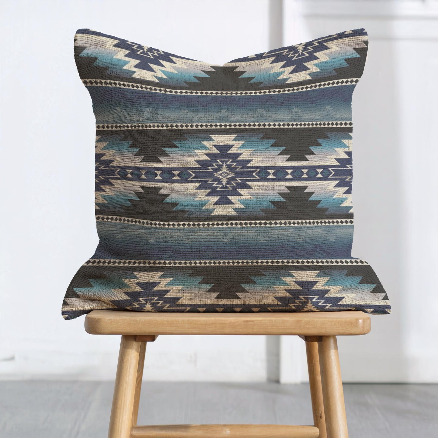 Southwestern throw pillow with geometric pattern styled on a sofa or bed