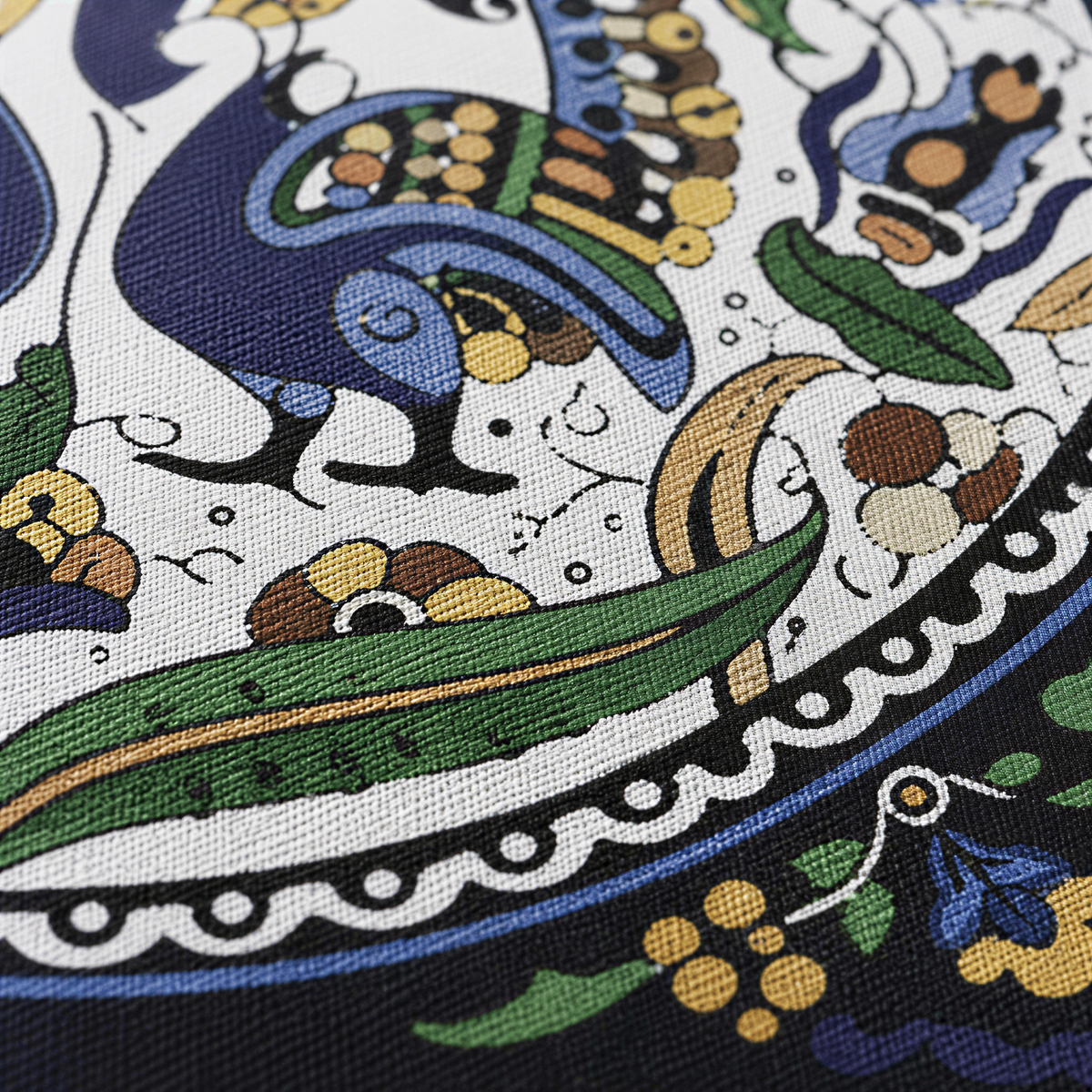 Close view of a medallion of paired blue peacocks with green leaves