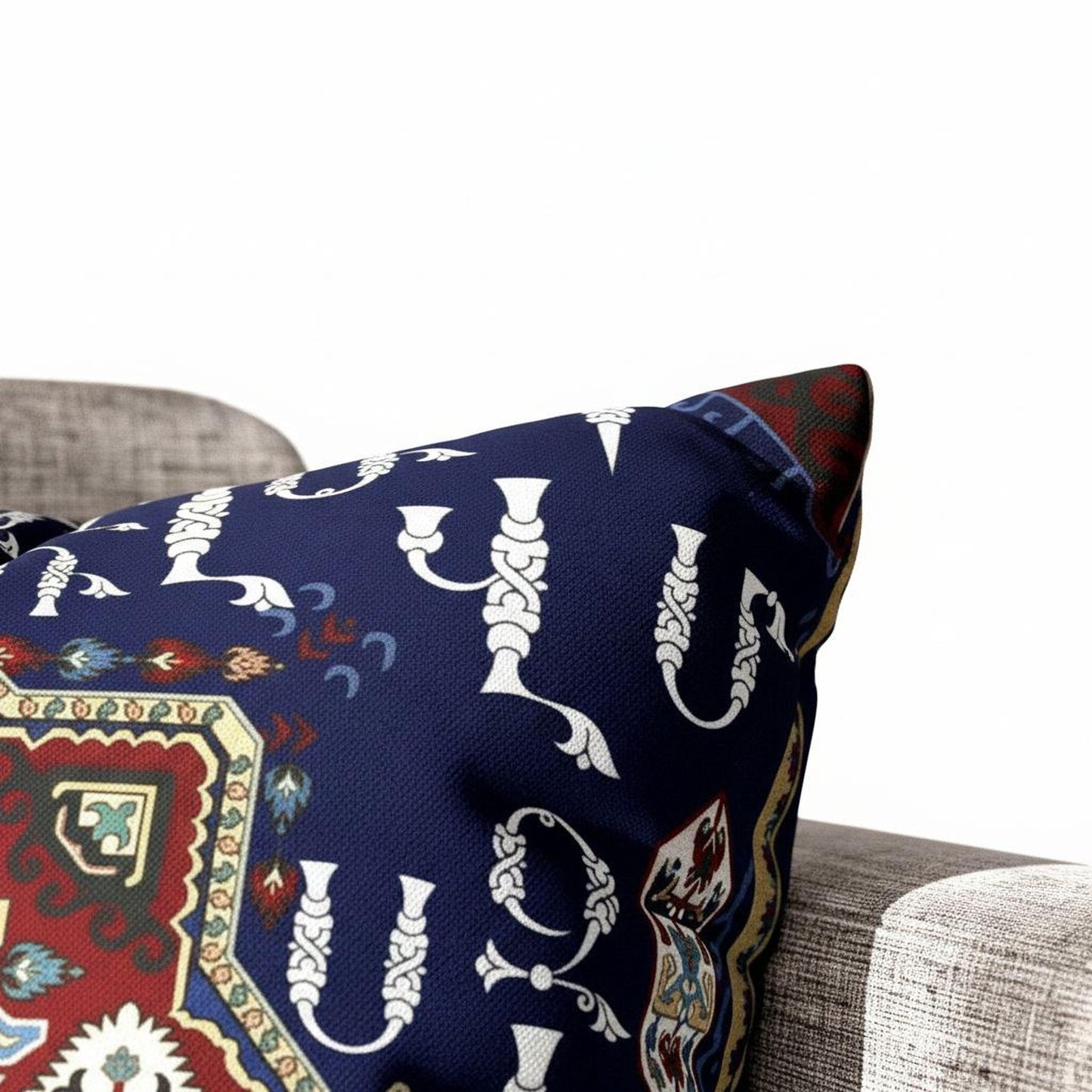 A close-up view of a decorative pillow with a blue and red pattern, featuring white silhouettes of various shapes and designs.