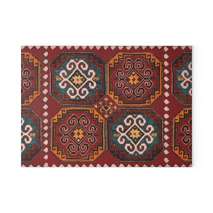 Red and gold Armenian rug motif cutting board on a wooden worktop with a knife alongside