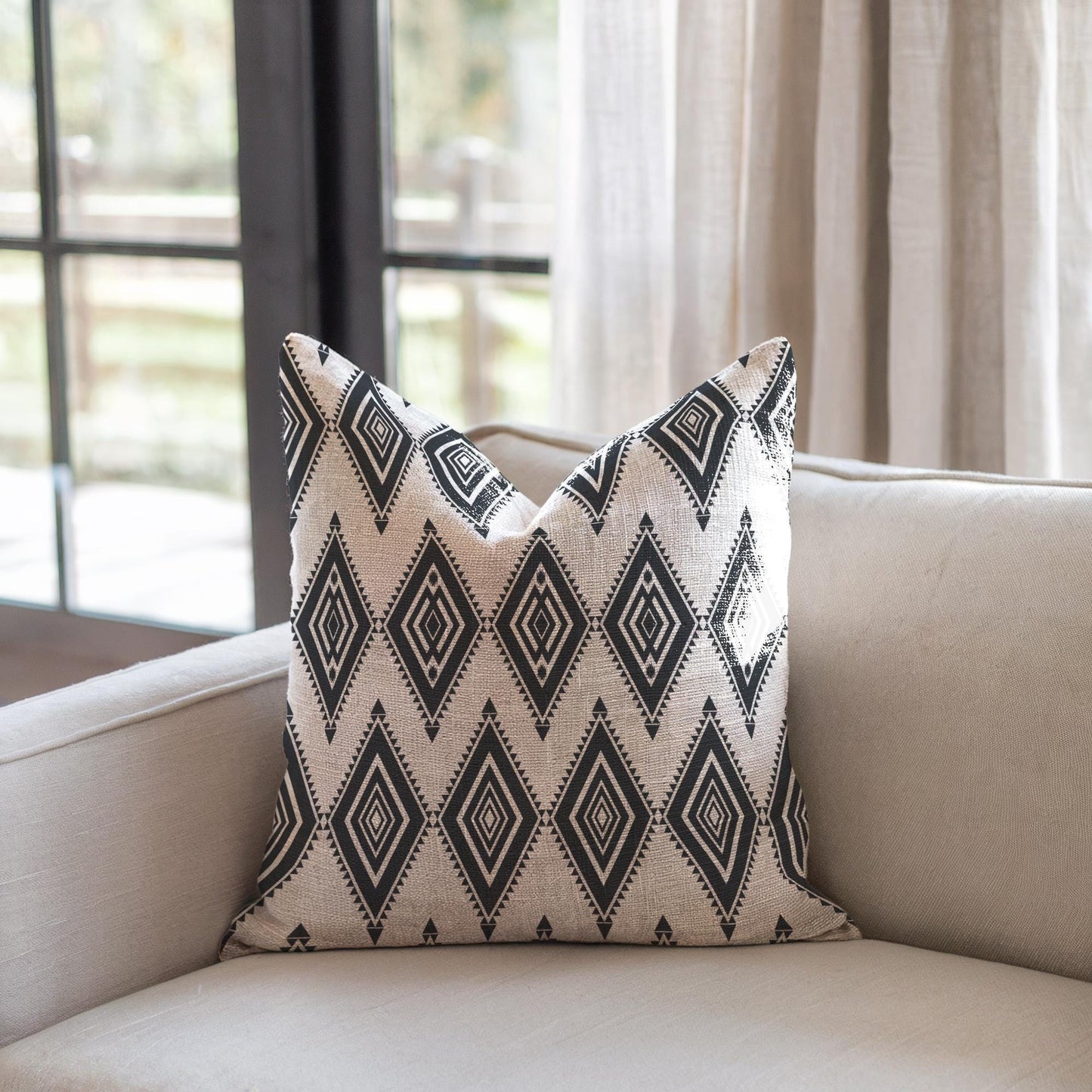 Southwestern throw pillow with geometric pattern styled on a sofa or bed