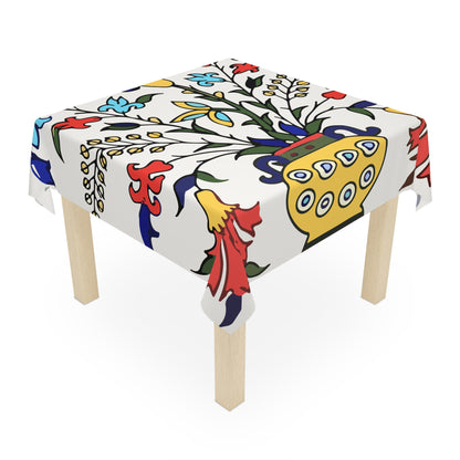 Yellow peacock Armenian tablecloth on a round dining table with a vase and a bowl of fruit