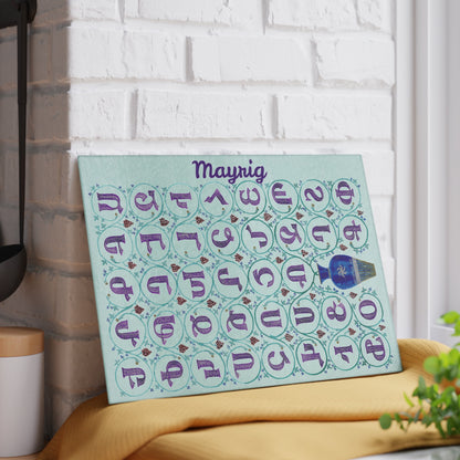 Mint Armenian alphabet cutting board with a name on a grey mat beside a knife and fresh herbs
