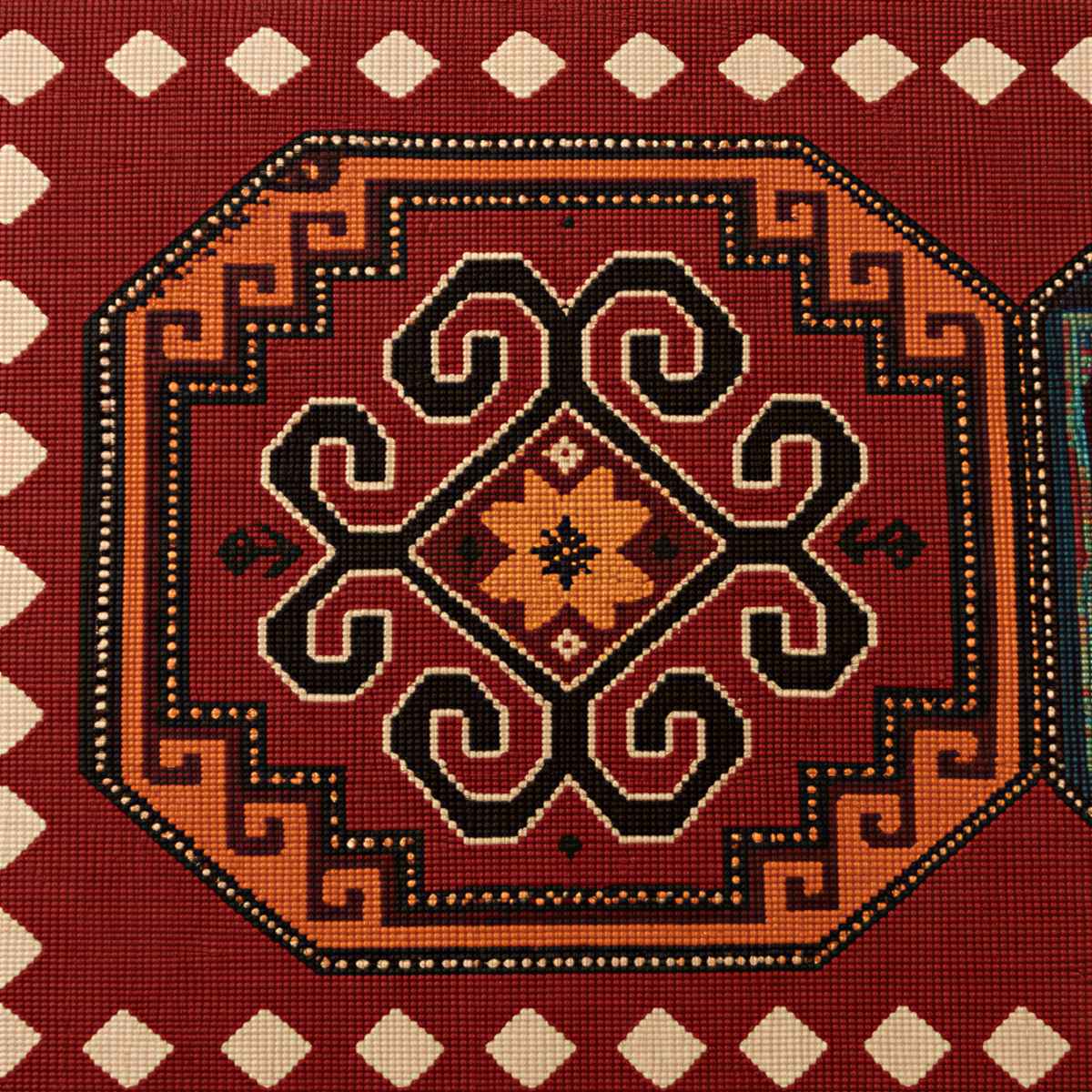 Close view of the octagonal carpet medallions in green, gold and cream on red