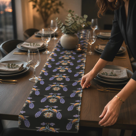 Black Armenian bird and flower table runner on a dining table set with white plates and glasses