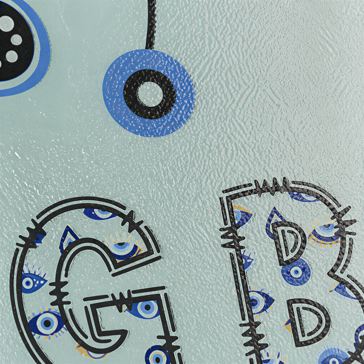 Close view of the initials G and B drawn in blue evil eye beads on mint glass