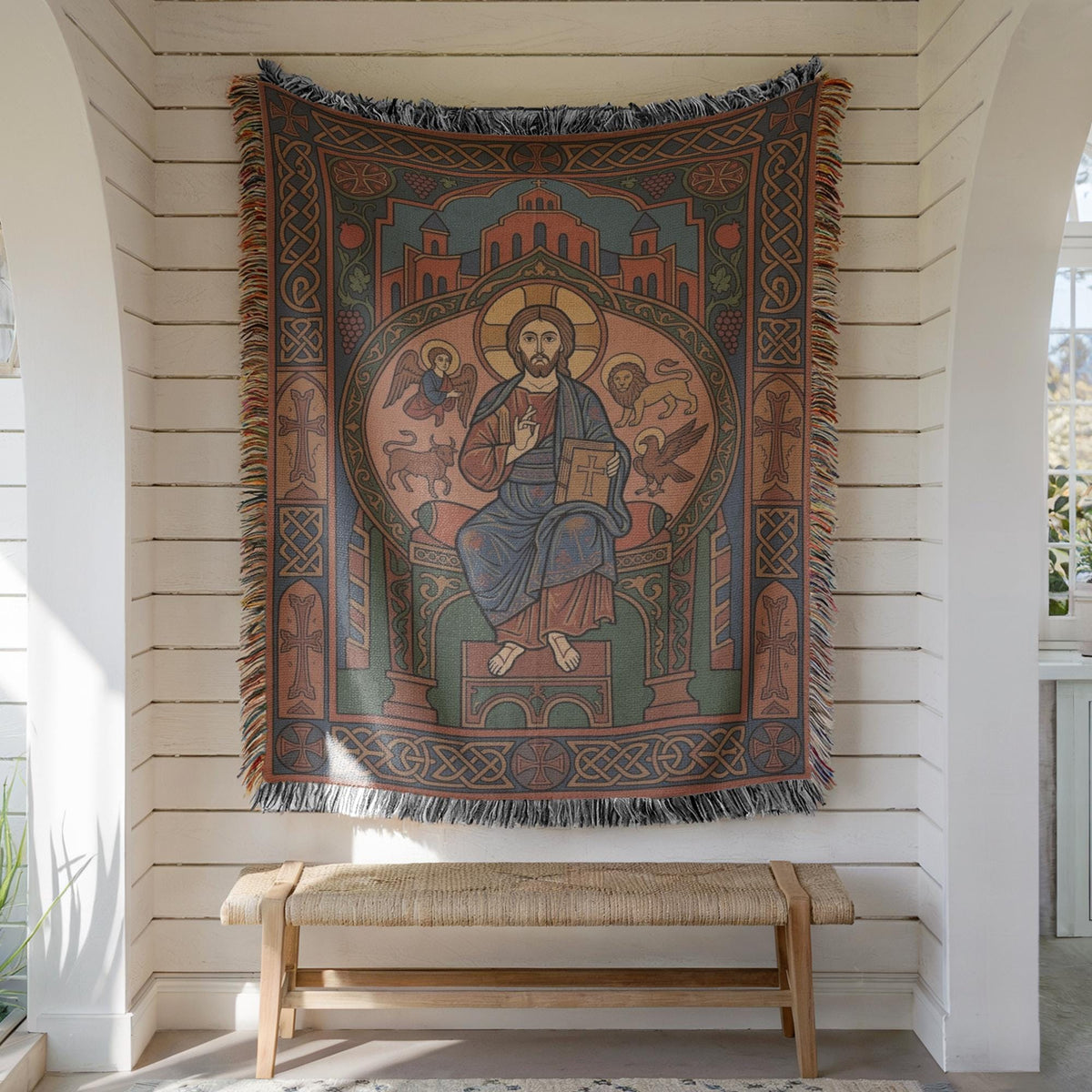Christ Pantocrator wall tapestry hung on white shiplap above a wooden bench