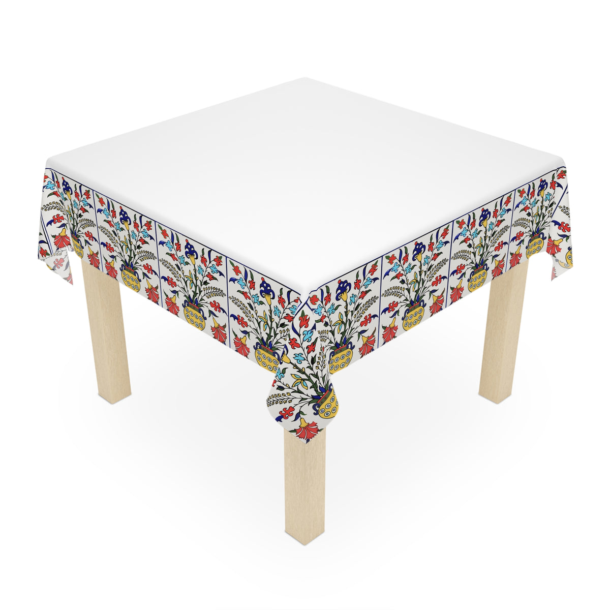 White Armenian tablecloth with floral border on a round dining table with a vase and a bowl of fruit