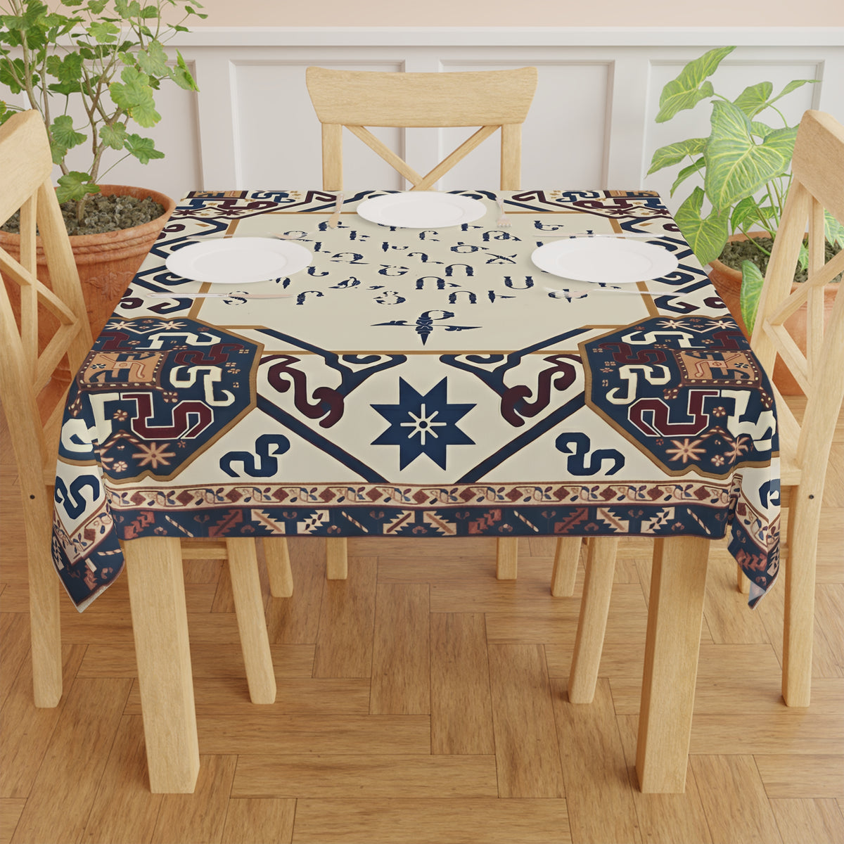 Armenian alphabet square tablecloth in cream on a wooden dining table set with plates
