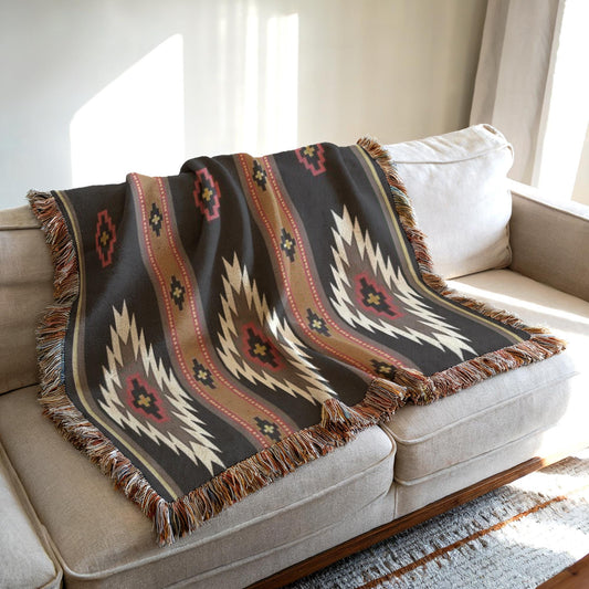 a cozy living room with a beige sofa and a decorative throw blanket with a colorful, geometric pattern on it.