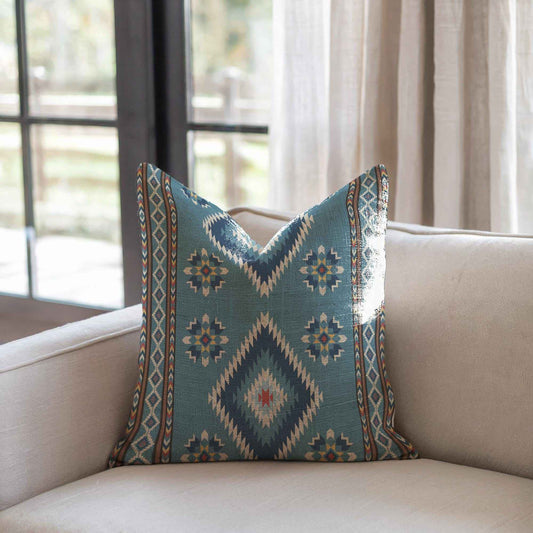 Southwestern throw pillow with geometric pattern styled on a sofa or bed