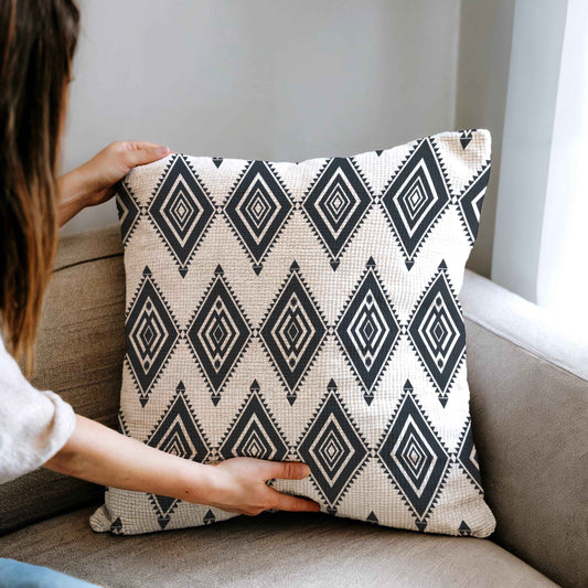 Southwestern throw pillow with geometric pattern styled on a sofa or bed