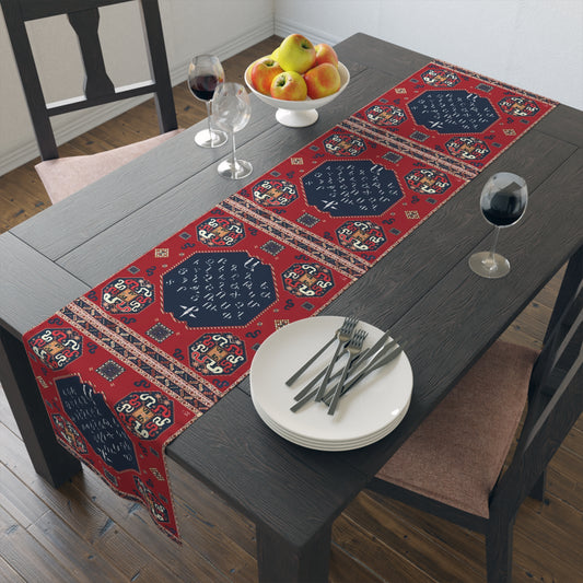 Armenian alphabet table runner in deep red on a dining table set with white plates and glasses