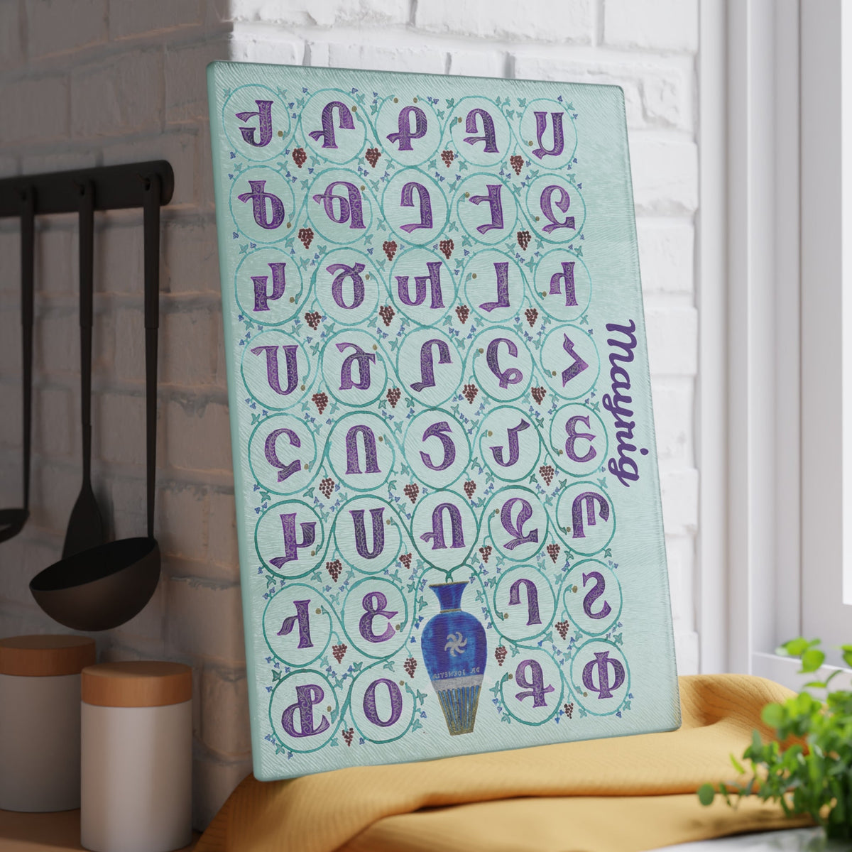 Mint Armenian alphabet cutting board with a name seen from above on a kitchen counter