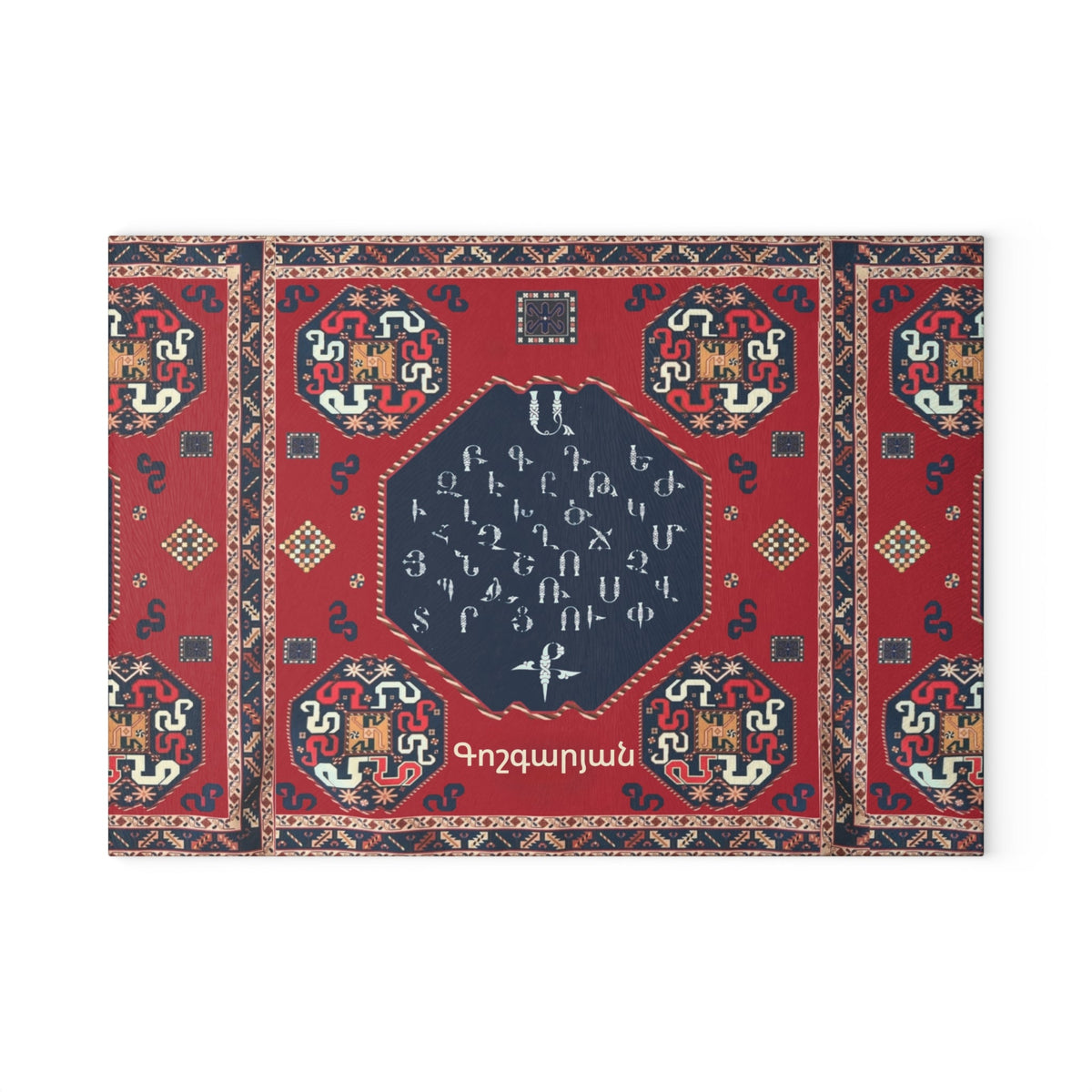 Red Armenian carpet cutting board with a family name on a grey mat beside a knife and fresh herbs