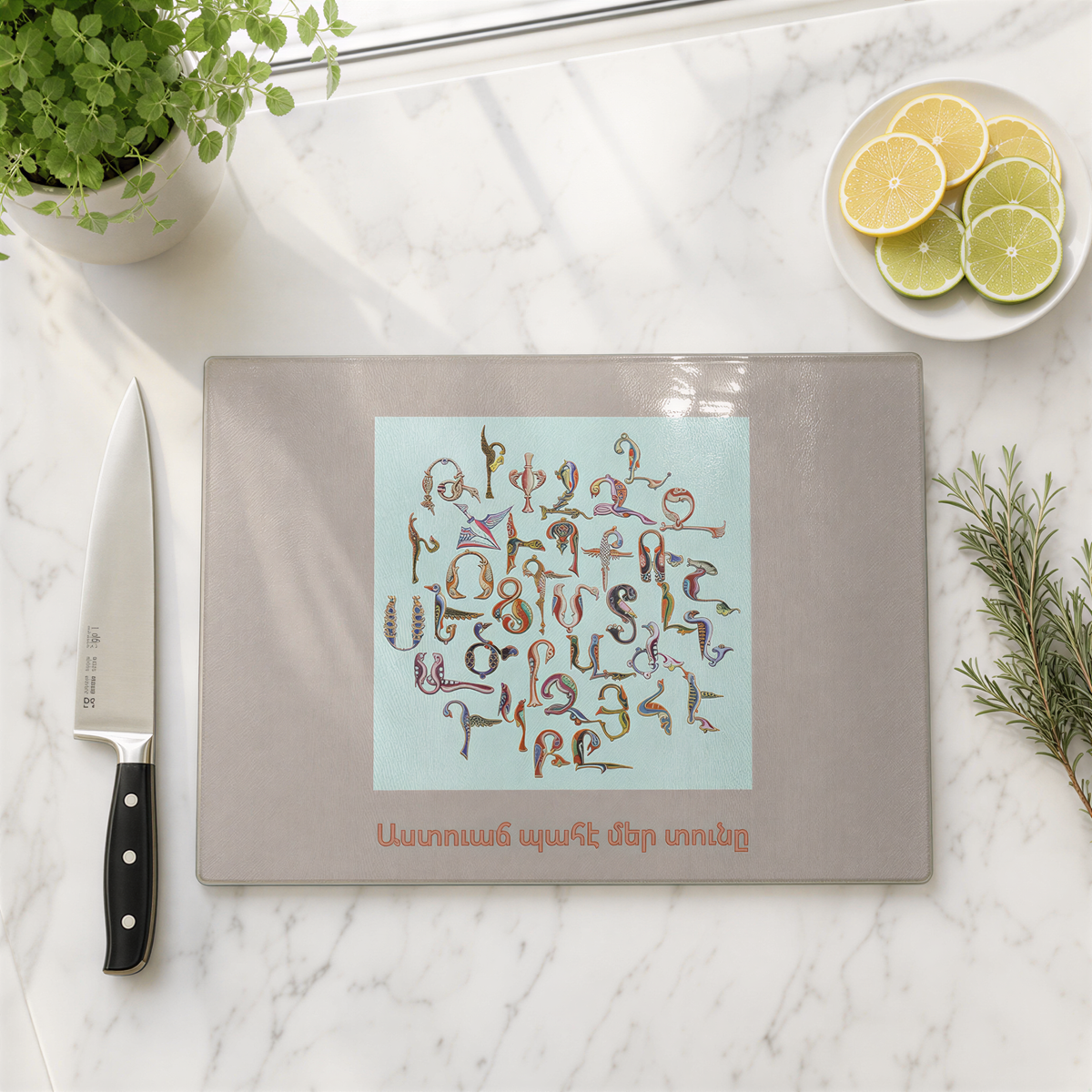 Armenian blessing cutting board on marble with a knife, lime slices and herbs