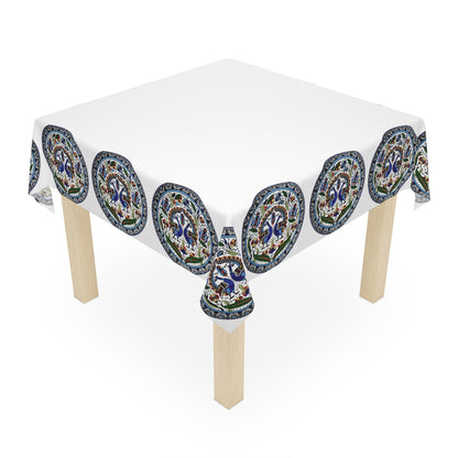 Armenian peacock medallion tablecloth on a round dining table with a vase and a bowl of fruit