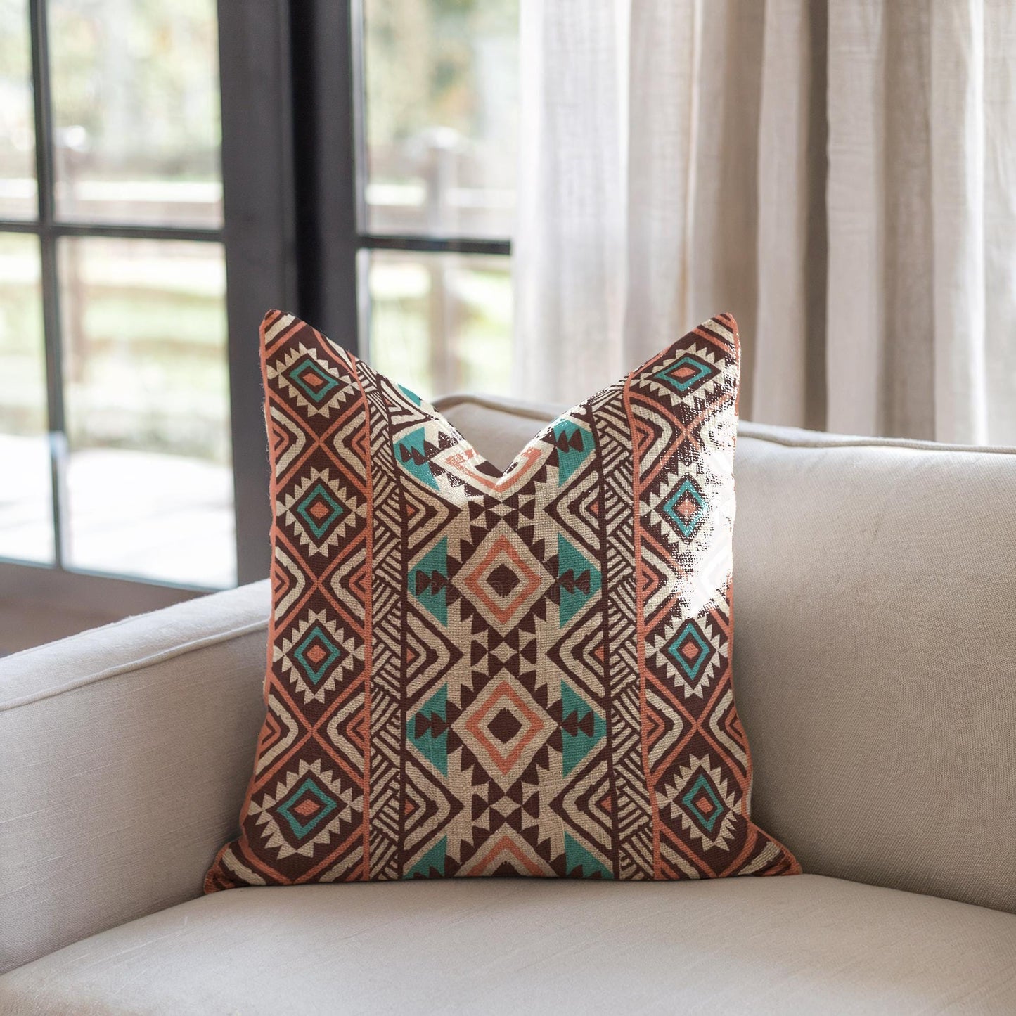 Southwestern pillow cover with geometric pattern styled on a sofa or bed