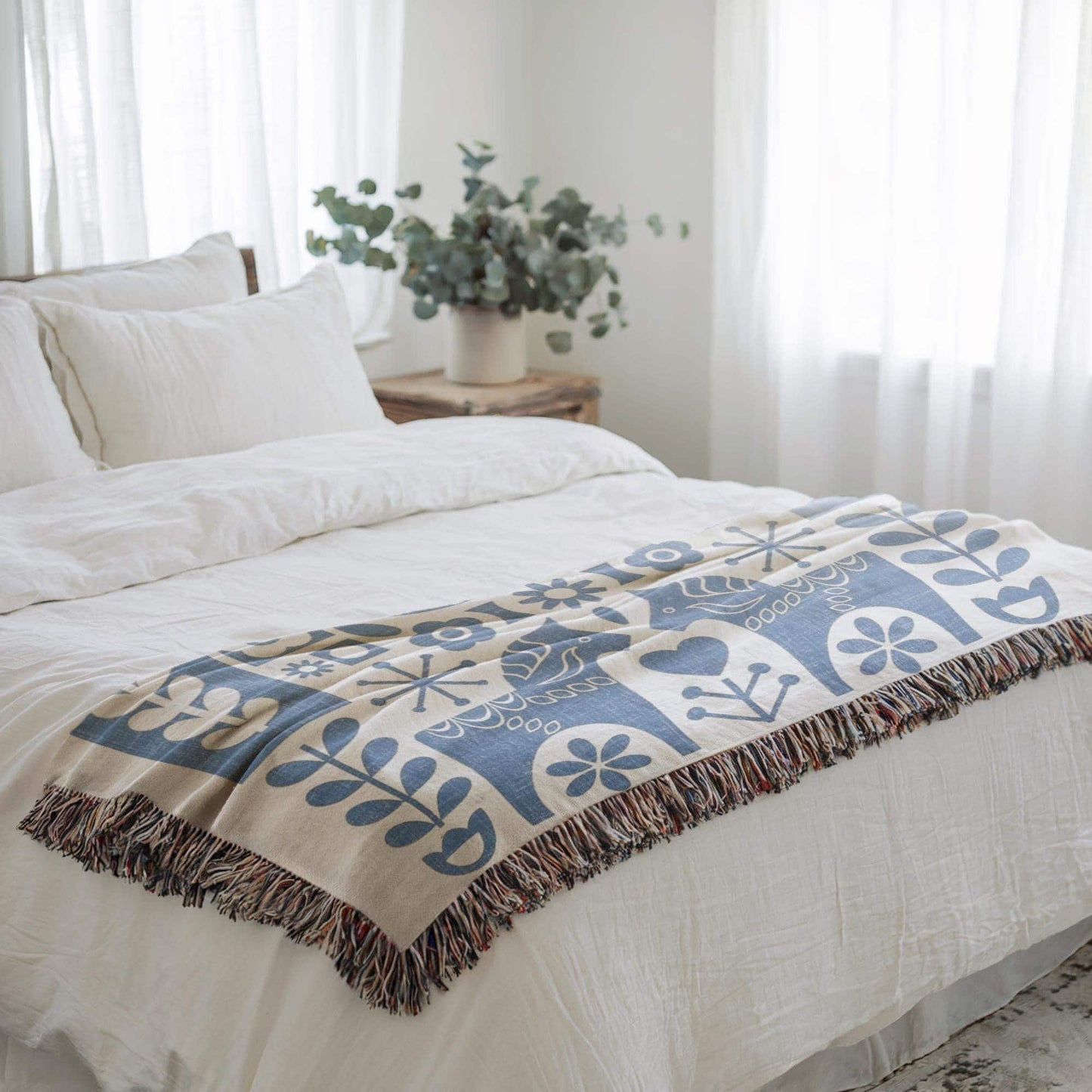 Scandinavian Inspired woven blanket with rug-style pattern styled for layered home decor