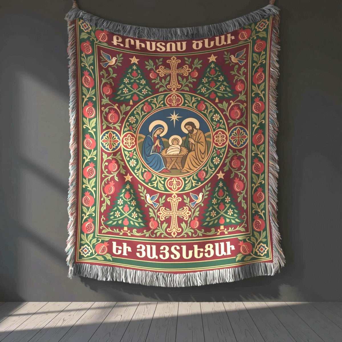 Armenian Christmas woven cotton blanket with fringe. A circular Nativity scene sits at the center of a deep green and burgundy design, framed by pomegranates, crosses, festive trees and Armenian Christmas lettering. Cream and muted gold details define the ornate border.