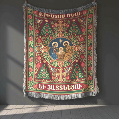 Armenian Christmas woven cotton blanket with fringe. A circular Nativity scene sits at the center of a deep green and burgundy design, framed by pomegranates, crosses, festive trees and Armenian Christmas lettering. Cream and muted gold details define the ornate border.