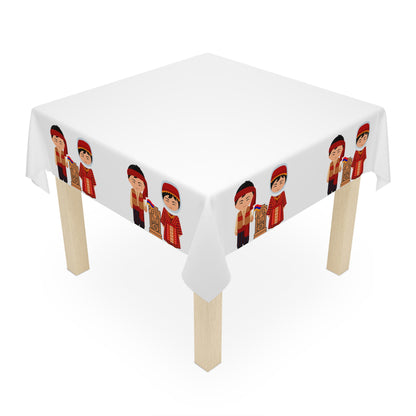 Armenian folk tablecloth with dress figures draped over a round table beside a window