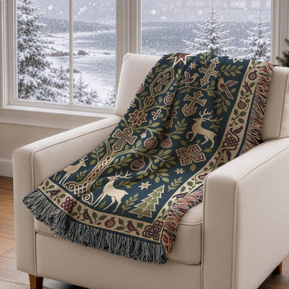 Armenian Christmas woven cotton blanket with fringe. Paired deer stand beside an ornamental pomegranate tree on a dark green background. Small crosses, stars, hanging ornaments and evergreen trees sit within a cream floral border with burgundy accents.