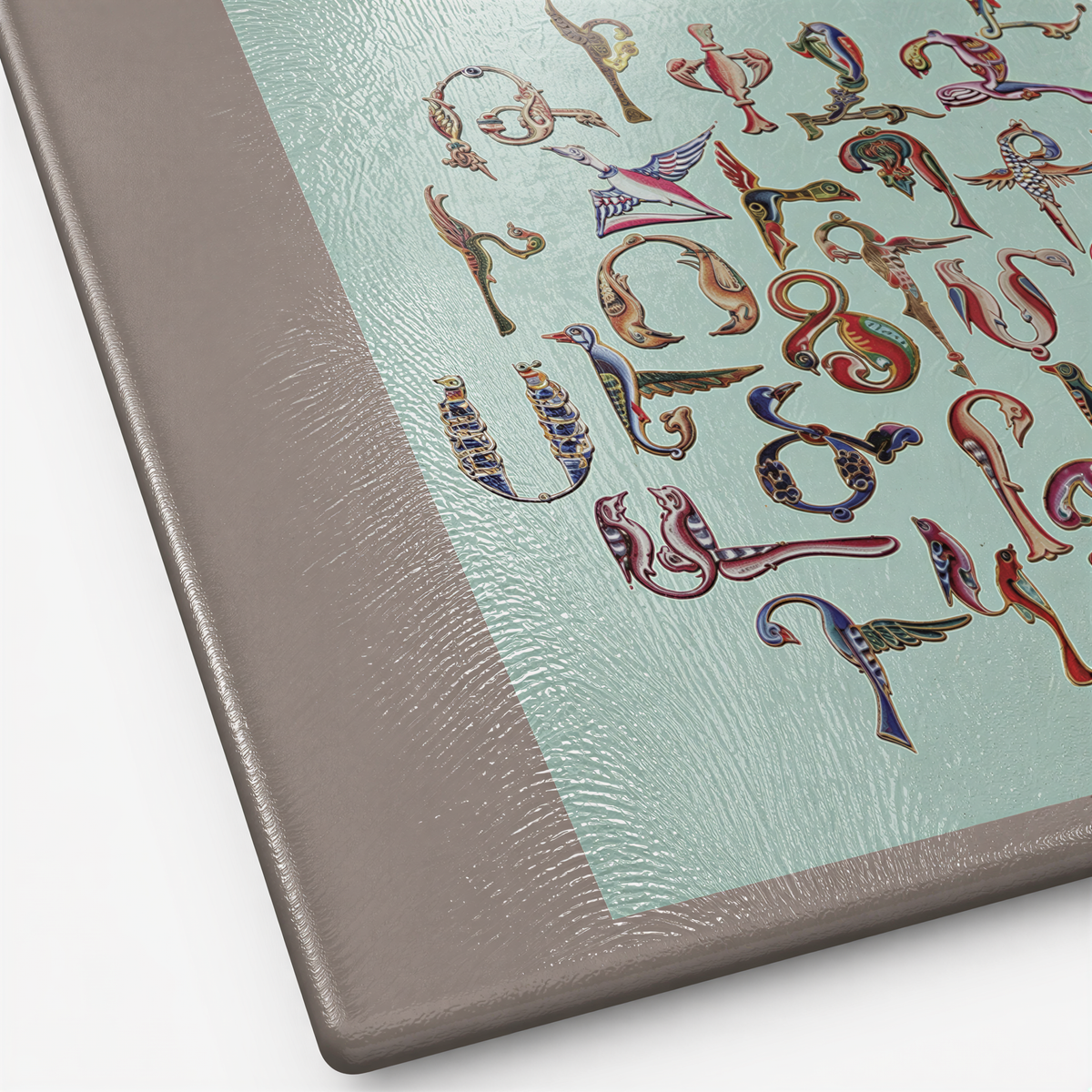 Close view of the Trchnakir bird letters in blue and gold on the mint glass surface